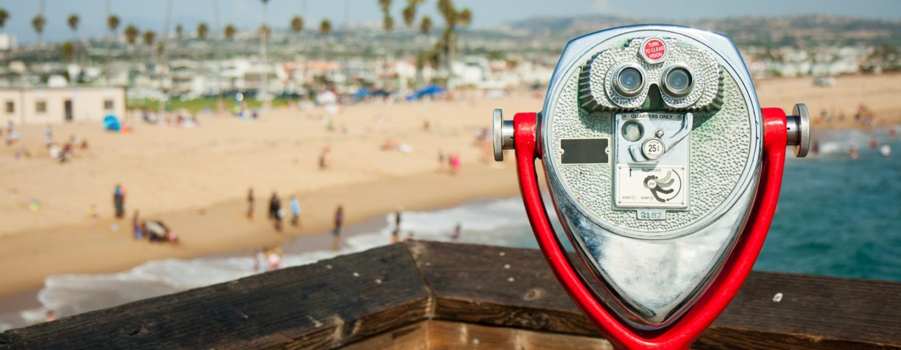 a red and white can on a railing overlooking a beach