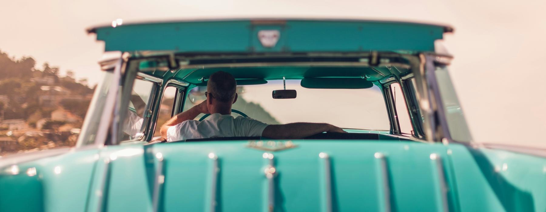 a person driving a green truck